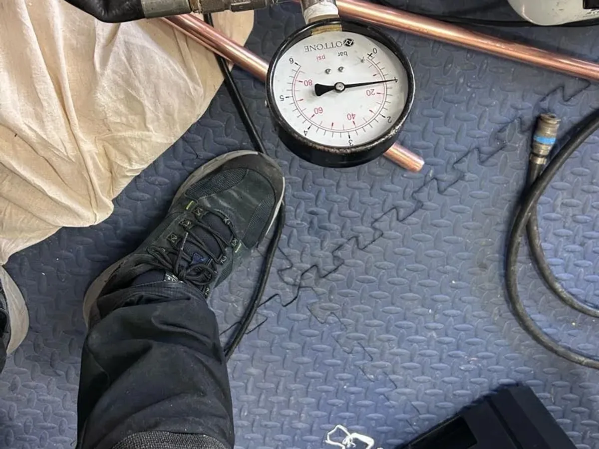 Pressure gauge reading zero on the floor beside the test hose